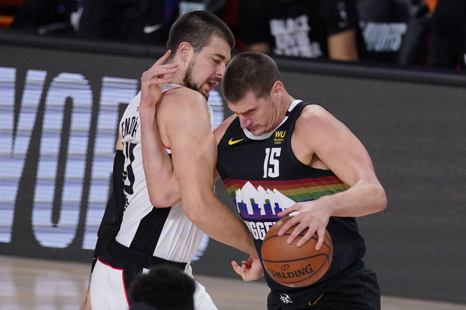 Los Angeles Clippers' Ivica Zubac, left, and Denver Nuggets' Nikola Jokic (15) tangle during the first half of an NBA conference semifinal playoff basketball game Monday, Sept. 7, 2020, in Lake Buena Vista, Fla. (AP Photo/Mark J. Terrill)