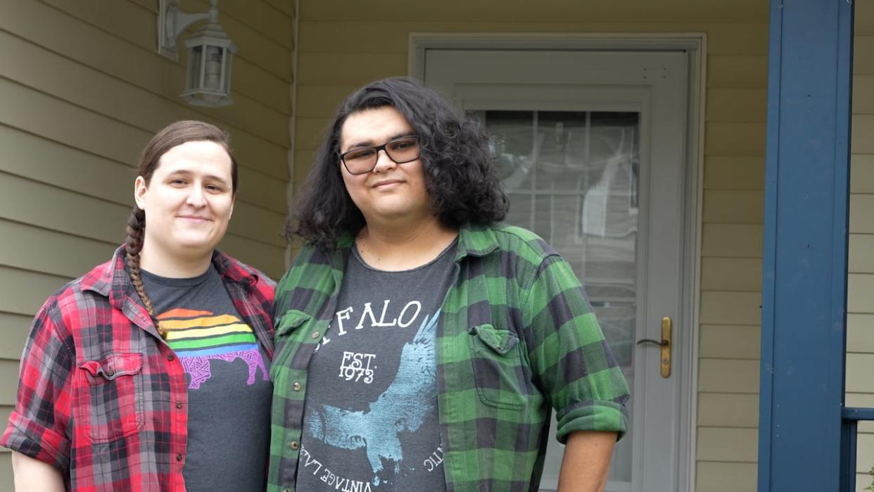 Madison, left, and Charlotte  Becerra stand in front of their home, which they purchased two years ago after leaving the U.S. The couple lives and works in B.C., but have been told they must pay $13,000 in vacancy tax because they are not Canadian citizens or permanent residents.  (Claire Palmer/CBC News  - image credit)