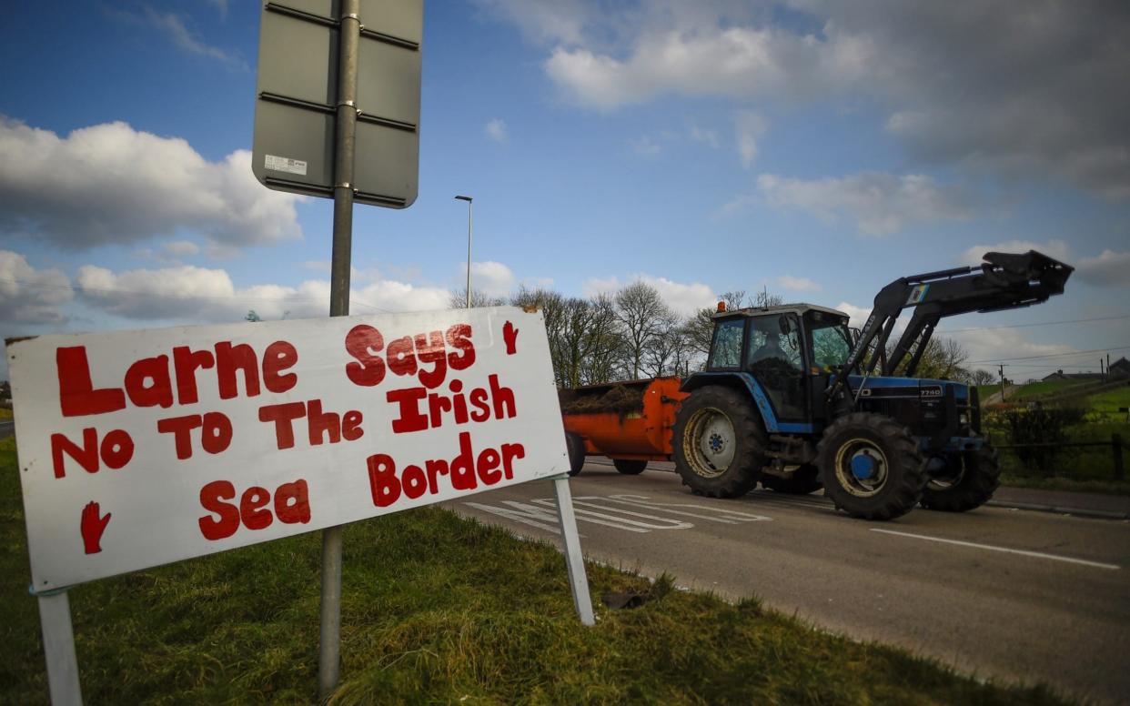 A sign against the Brexit border checks in relation to the Northern Ireland protocol at the harbour in Larne - CLODAGH KILCOYNE/REUTERS