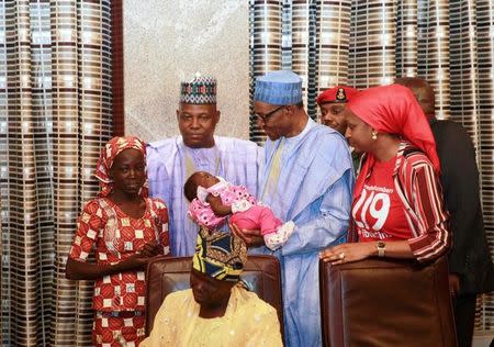 Amina Ali Darsha Nkeki, a Nigerian schoolgirl rescued after over two years of captivity with Boko Haram militants, presents her child to President Muhammadu Buhari in Abuja, Nigeria May 19, 2016. REUTERS/Afolabi Sotunde