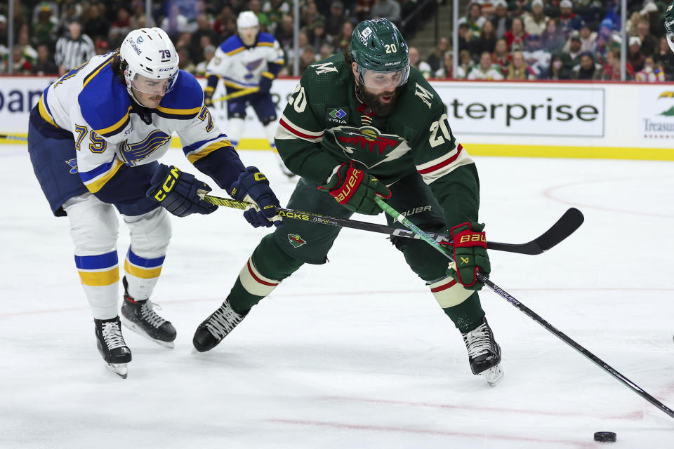 Minnesota Wild left wing Pat Maroon, right, skates with the puck as St. Louis Blues left wing Sammy Blais (79) defends during the third period of an NHL hockey game Tuesday, Nov. 28, 2023, in St Paul, Minn. (AP Photo/Matt Krohn)