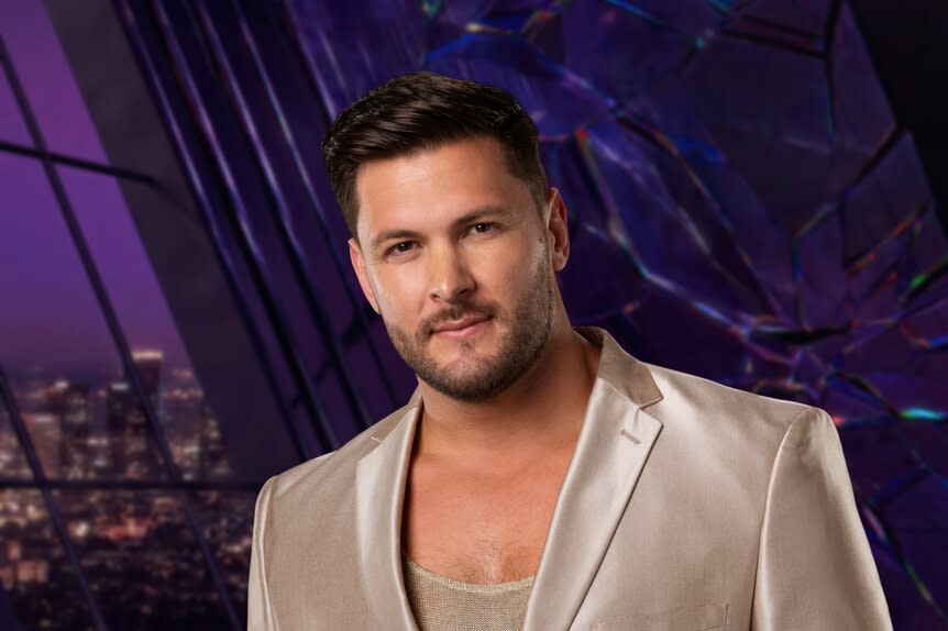 Brock Davies wears a gold blazer in his Season 11 promo picture.