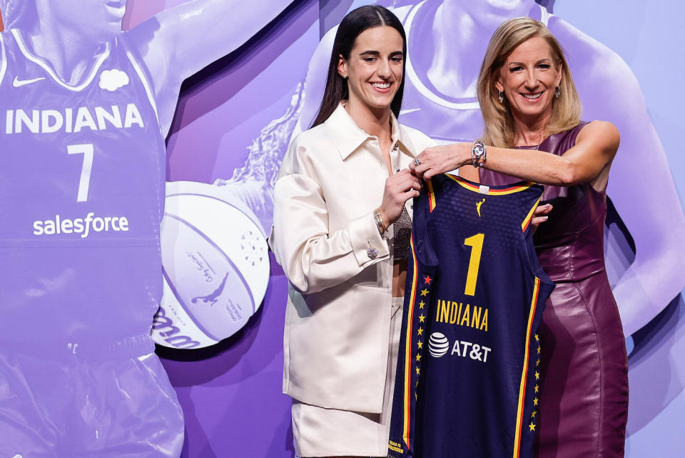 Caitlin Clark, left, holds an Indiana Fever jersey and poses for a photo with Cathy Engelbert (Adam Hunger / AP file)