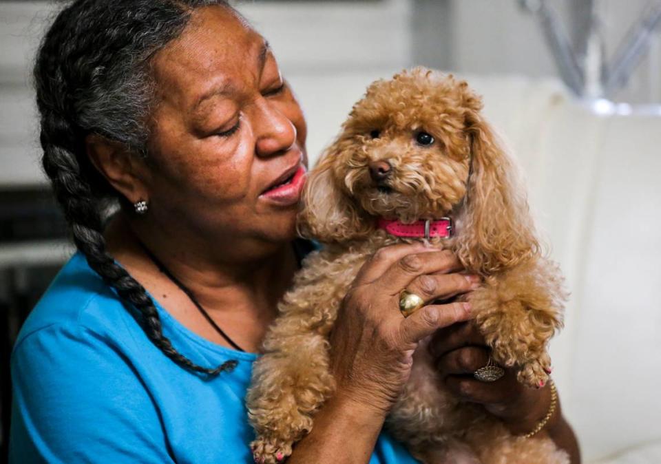 Troy Gardner holds her dog, Cupcake, inside her house on Genevieve Avenue in the Walnut Park East neighborhood of St. Louis on Thursday, July 22, 2021. Gardner says Cupcake used to love watching fireworks outside on the front porch, but the constant barrage of gunfire in the neighborhood has made her scared of any loud noises, including fireworks.