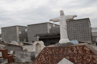 A small version of the Christ the Redeemer statue stands in front of niches at the Iraja cemetery, where many COVID-19 victims are buried in Rio de Janeiro, Brazil, Friday, Feb. 5, 2021. (AP Photo/Silvia Izquierdo)