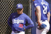 Los Angeles Dodgers manager Dave Roberts, left, watches as his pitcher Walker Buehler participates in spring training baseball workouts at Camelback Ranch in Phoenix, Wednesday, March 13, 2024. (AP Photo/Darryl Webb)