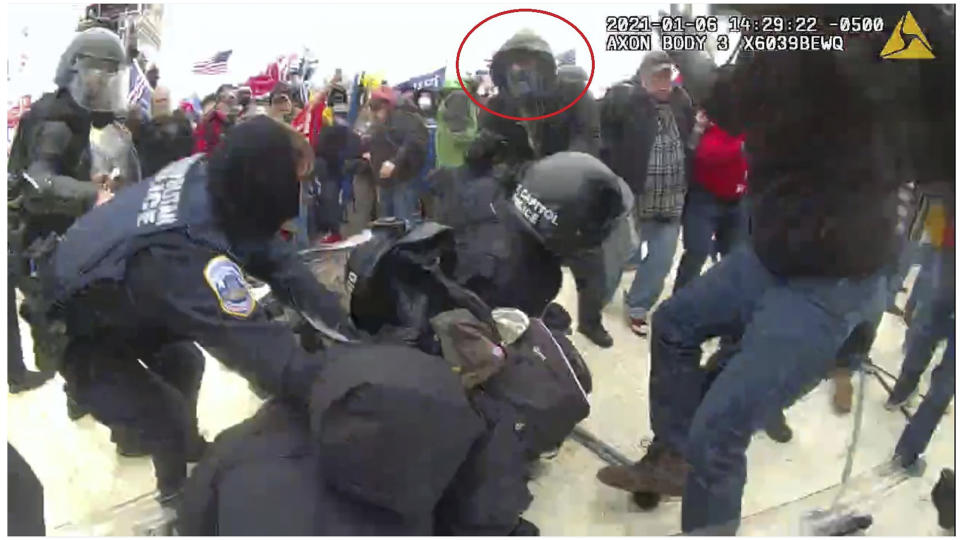 This image from police body-worn camera video, contained and annotated in the Justice Department's government's sentencing memorandum supporting the sentencing of Brian Mock, shows Mock at the U.S. Capitol on Jan. 6, 2021, in Washington. Mock, the owner of a landscaping company and a former debt collector, was arrested for helping other rioters remove police barricades and committing four separate assaults against police officers who were attempting to block the rioters’ progression. (Department of Justice via AP)