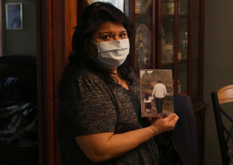 Estela Hernanez, a daughter of longtime JBS USA meat packing plant employee Saul Sanchez, holds a photo of him in Greeley