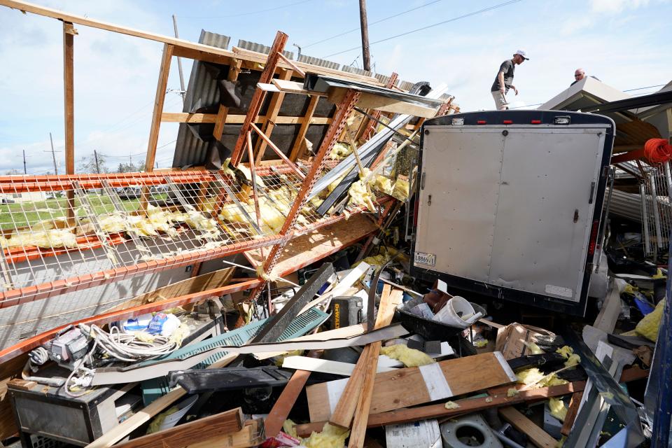 Jeremy Hodges, left, and his brother Jacob work to clear their storage unit in the aftermath of Hurricane Ida, Monday, Aug. 30, 2021, in Houma, La.