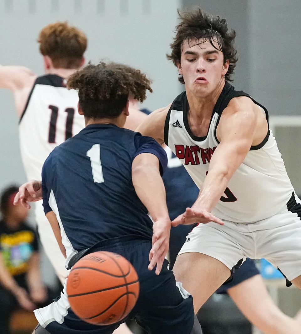 Greenwood Christian Academy Cougars Jordan Taulman (1) passes the ball away from Bethesda Christian Patriots Sam Mlagan (3) on Thursday, Feb. 9, 2023 at Bethesda Christian High School in Brownsburg. The Greenwood Christian Academy Cougars defeated the Bethesda Christian Patriots, 66-43. 