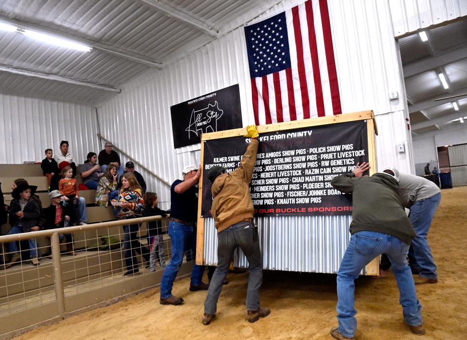 Stock show dads wrestle the auctioneer’s rostrum into place for the sale at the Shackleford County Youth & Livestock Show in Albany Jan. 20.