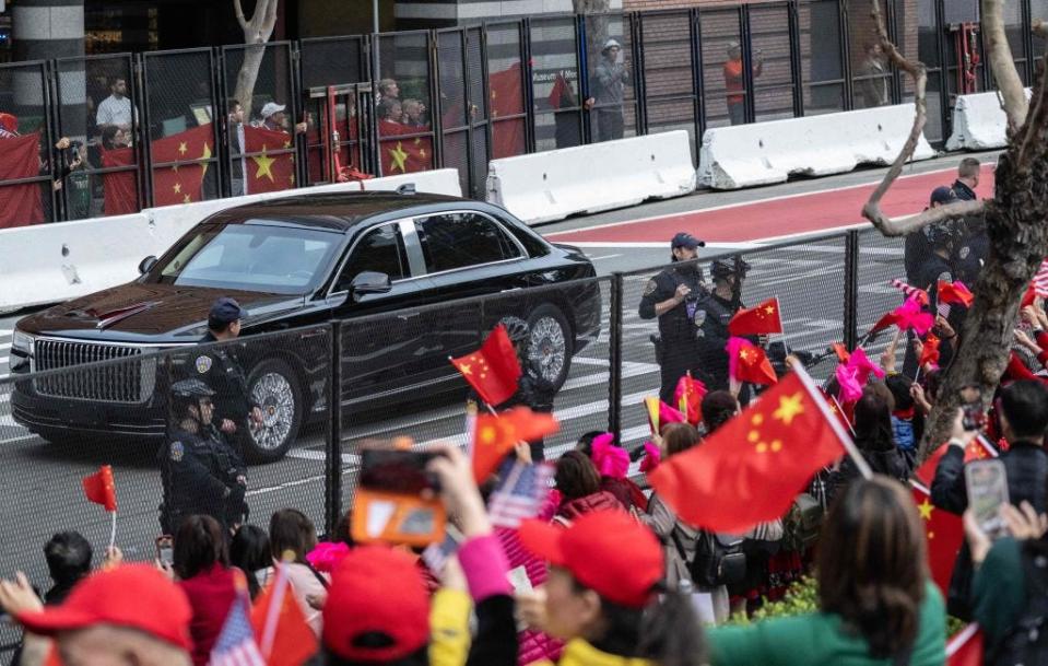 Motorcade of China's President Xi Jinping drives through San Francisco as supporters wave flags.
