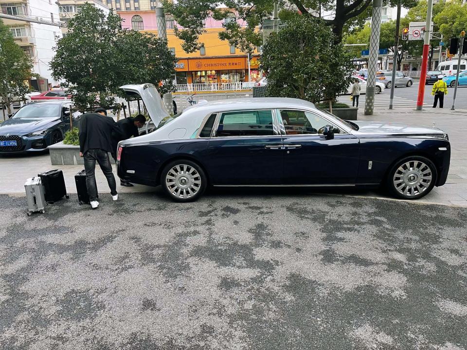 The man is seen placing the money, which is in suitcases, inside his luxury car. Source: AsiaWire/Australscope