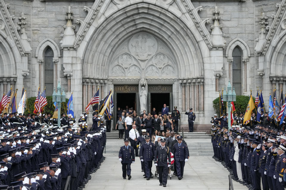 The casket of Newark firefighter Augusto "Augie" Acabou is carried from the Cathedral Basilica of the Sacred Heart with family members and friends in tow during his funeral days after he died battling a fire aboard the Italian-flagged Grande Costa d'Avorio cargo ship at the Port of Newark, Thursday, July 13, 2023, in Newark, N.J. The fire claimed the lives of Acabou and Wayne "Bear" Brooks Jr. (AP Photo/John Minchillo)