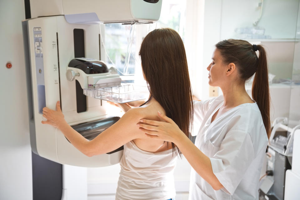 Female doctor and mid adult woman during Mammography test in examination room. breast cancer screening