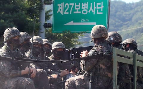 South Korean soldiers ride on a military truck in the border county of Hwacheon - Credit: AFP/YONHAP/STR