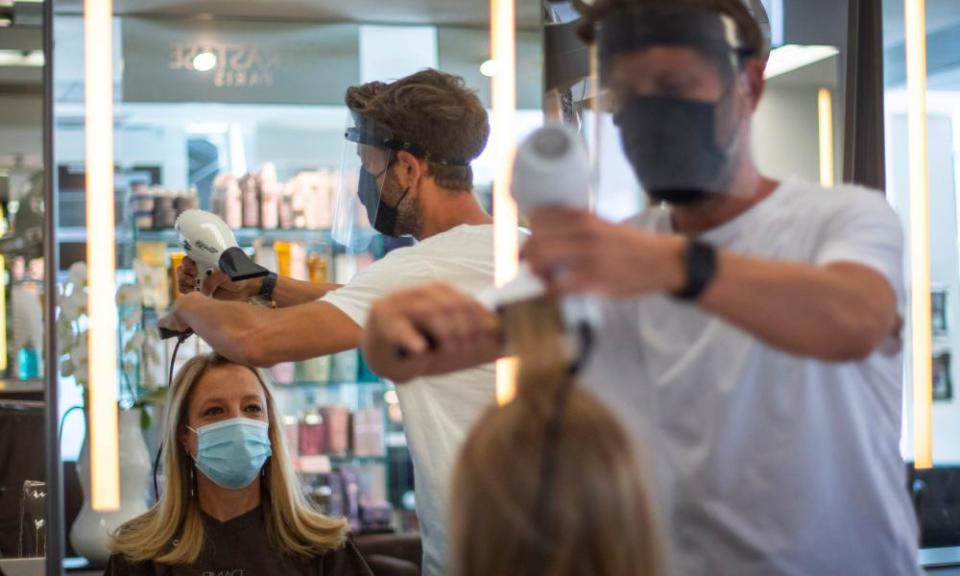 Hairdresser Nick Peters cuts a staff member’s hair at their salon in Marylebone, central London.