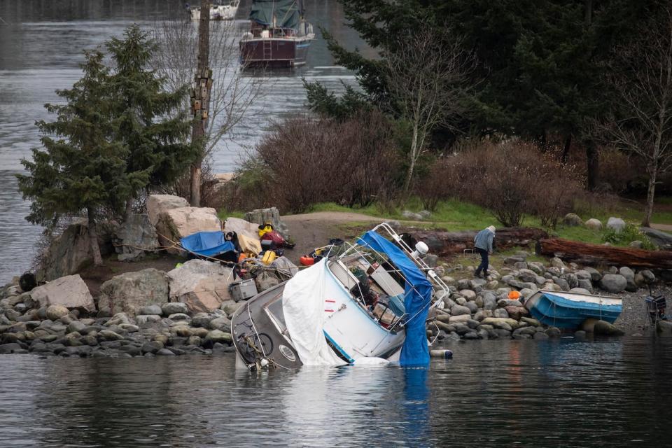 A boat is pictured overwhelmed with water in False Creek in Vancouver, British Columbia on Wednesday, December 27, 2023. 