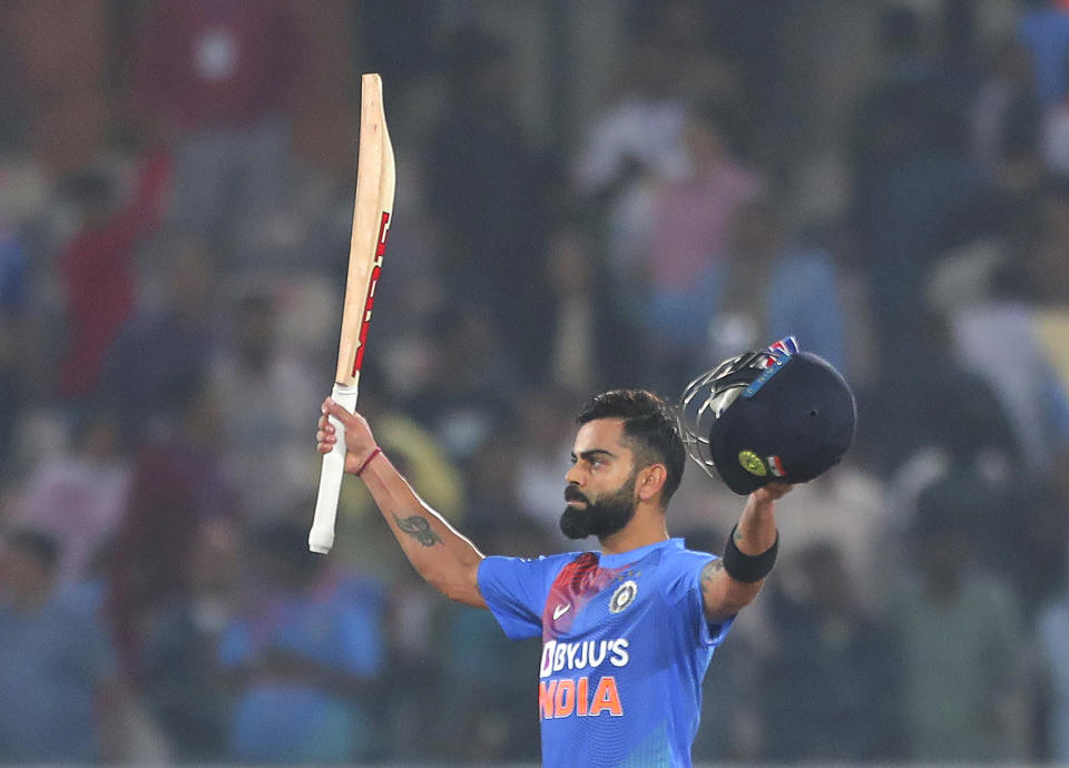 India's captain Virat Kohli raises his bat and helmet to celebrate their win against West Indies during their first Twenty20 international cricket match in Hyderabad, India, Friday, Dec. 6, 2019. (AP Photo/Mahesh Kumar A.)