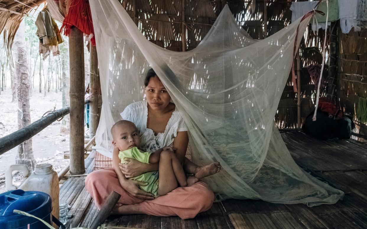 A mother sits under a bed net with her two-year-old son in Mon State, Myanmar - Vlad Sokhin/WHO 2016