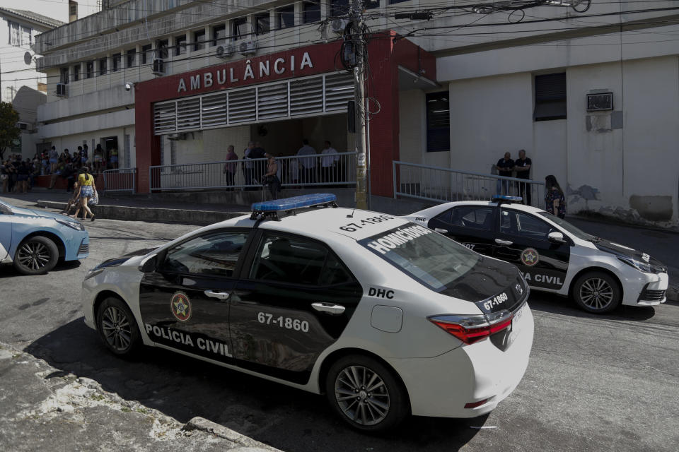 Police vehicles are parked in front of the hospital where the victims of a police raid that killed at least 9 people in the Vila Cruziero favela were admitted, in Rio de Janeiro, Brazil, Wednesday, Aug. 2, 2023. Police said the raid targeted criminal gangs in Rio's favela. (AP Photo/Bruna Prado)