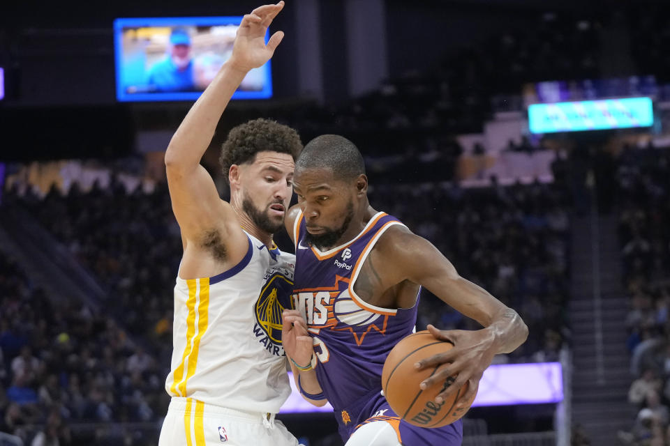 Phoenix Suns forward Kevin Durant, right, drives to the basket against Golden State Warriors guard Klay Thompson during the first half of an NBA basketball game in San Francisco, Tuesday, Oct. 24, 2023. (AP Photo/Jeff Chiu)