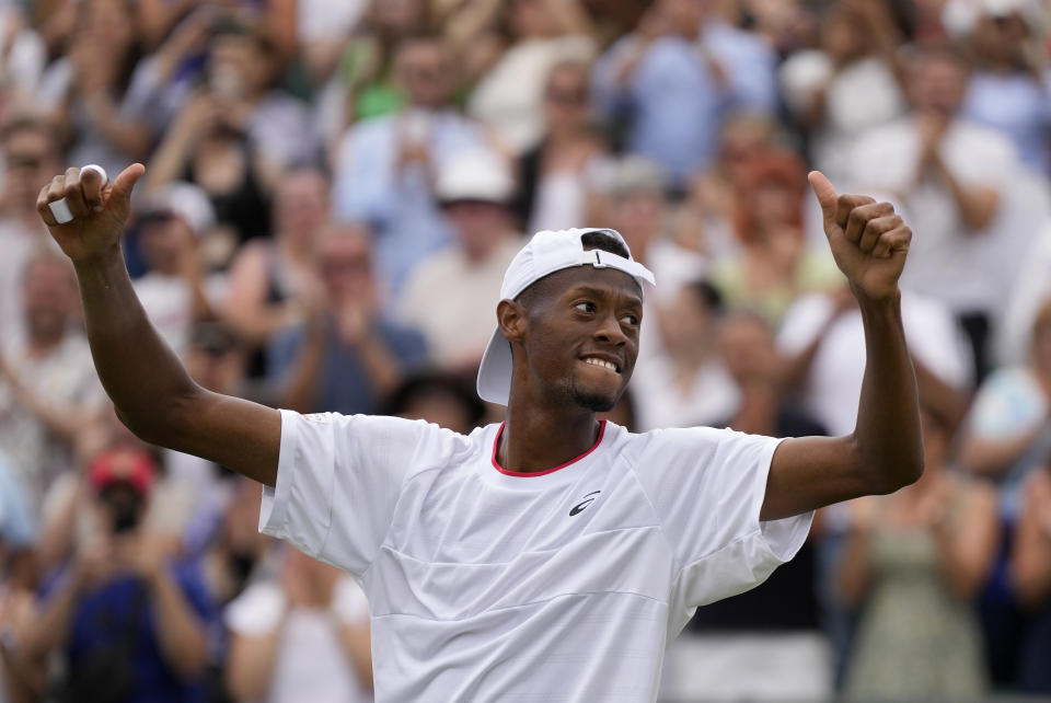 Christopher Eubanks of the US celebrates after beating Stefanos Tsitsipas of Greece in a men's singles match on day eight of the Wimbledon tennis championships in London, Monday, July 10, 2023. (AP Photo/Alastair Grant)