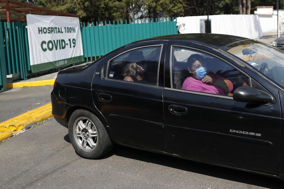 María Del Carmen Acero Camacho, de 48 años, a la derecha, deja el hospital junto con familiares después de una hospitalización de 21 días por COVID-19, en Iztapalapa, Ciudad de México, el lunes 25 de mayo de 2020. (AP Foto/Rebecca Blackwell)