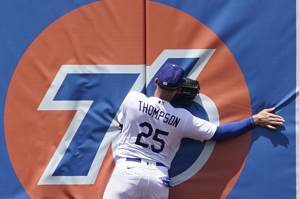 Los Angeles Dodgers center fielder Trayce Thompson crashes into the outfield wall after catching a line drive from Washington Nationals' Luis Garcia during the fifth inning of a baseball game Wednesday, July 27, 2022, in Los Angeles. (AP Photo/Marcio Jose Sanchez)