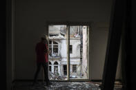An engineer inspects a residential building heavily damaged in last week's explosion that hit the seaport of Beirut, Lebanon, Tuesday, Aug. 11, 2020. (AP Photo/Felipe Dana)