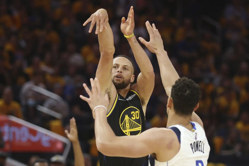 Golden State Warriors guard Stephen Curry (30) watches his 3-point basket against Dallas Mavericks center Dwight Powell during the second half of Game 1 of the NBA basketball playoffs Western Conference finals in San Francisco, Wednesday, May 18, 2022. (AP Photo/Jed Jacobsohn)