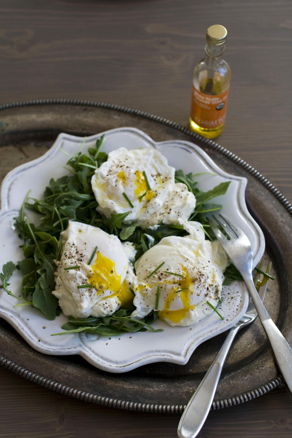 In this image taken Dec. 3, 2012, poached eggs over ricotta cheese on arugula are shown served on a plate in Concord, N.H. (AP Photo/Matthew Mead)