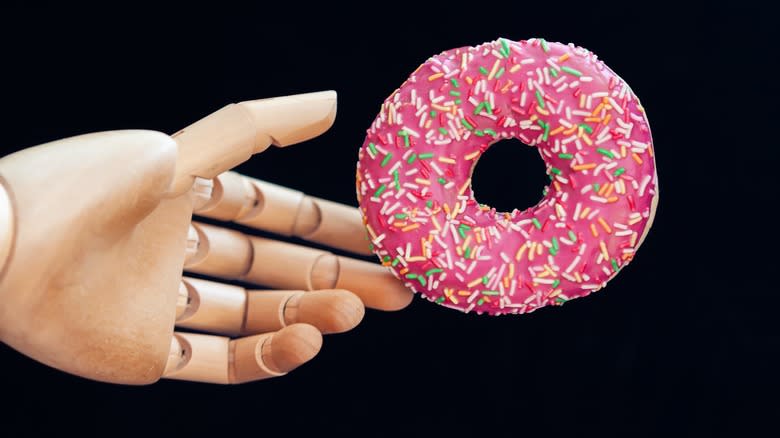 mannequin hand holding donut