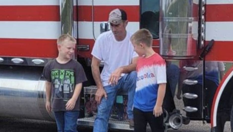 David Schultz sits on his rig along with his twin sons.