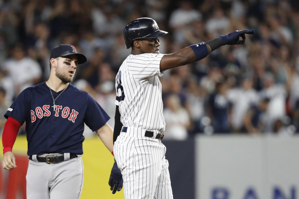 Boston Red Sox second baseman Marco Hernandez, left, watches as New York Yankees' Cameron Maybin gestures toward the Yankees' dugout after hitting a two-run double during the third inning in the second baseball game of a doubleheader Saturday, Aug. 3, 2019, in New York. (AP Photo/Kathy Willens)