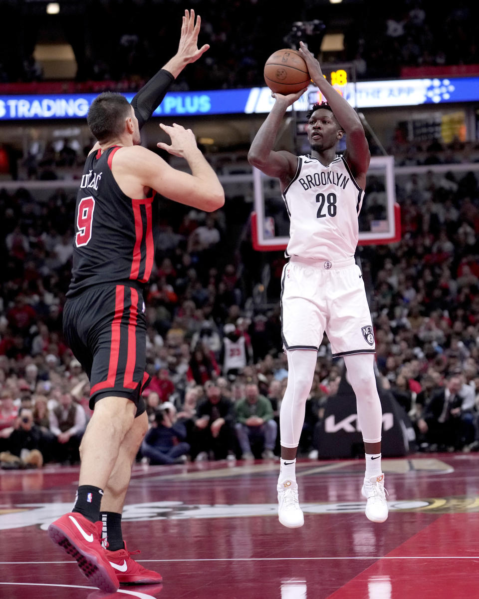 Brooklyn Nets' Dorian Finney-Smith (28) shoots as Chicago Bulls' Nikola Vucevic, left, defends during the second half of an NBA in-season tournament basketball game Friday, Nov. 3, 2023, in Chicago. (AP Photo/Charles Rex Arbogast)