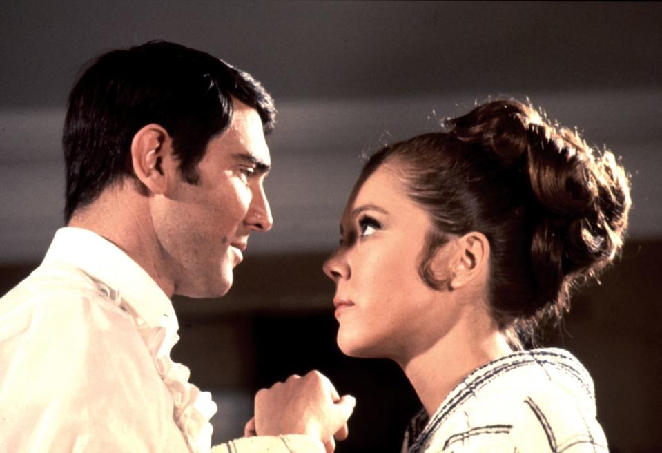 Teresa Di Vicenzo (Diana Rigg) ist die einzige Frau, mit der James Bond (hier: George Lazenby) jemals verheiratet war. Er lernt sie kennen, nachdem er sie vom geplanten Selbstmord abgehalten hat. 007 verliebt sich ernsthaft in sie. Beide planen sogar ihre gemeinsame Zukunft, Kinder inklusive. Doch dann wird Teresa von Irma Bunt, einer Schergin des Schurken Ernst Stavro Blofeld, erschossen. Jahre später besucht Bond in "In tödlicher Mission" ihr Grab. (Bild: United Artists)