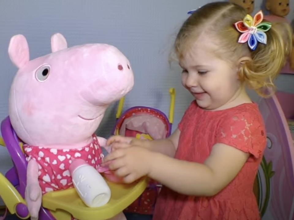 A picture of Diana playing with a Peppa Pig.