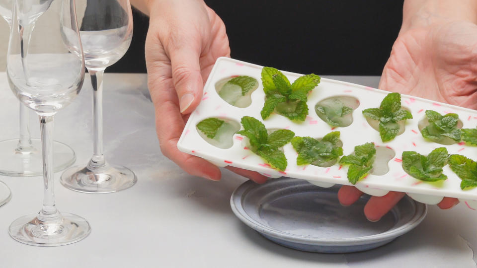 Heart shaped ice cubes with frozen mint leaves close up.  Drinks with frozen mint leaves recipe