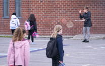 Primary school teacher Celine Guerin explains the 2-metre distancing to her students in the school yard of the Marie-Derome School in Saint-Jean-sur-Richelieu, Que. on Monday, May 11, 2020. Primary schools and daycares outside of the greater Montreal area gradually open Monday. THE CANADIAN PRESS/Paul Chiasson