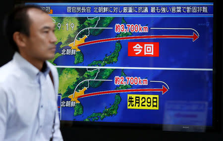 A passerby walks past a TV screen reporting news about North Korea's missile launch in Tokyo, Japan September 15, 2017. REUTERS/Issei Kato