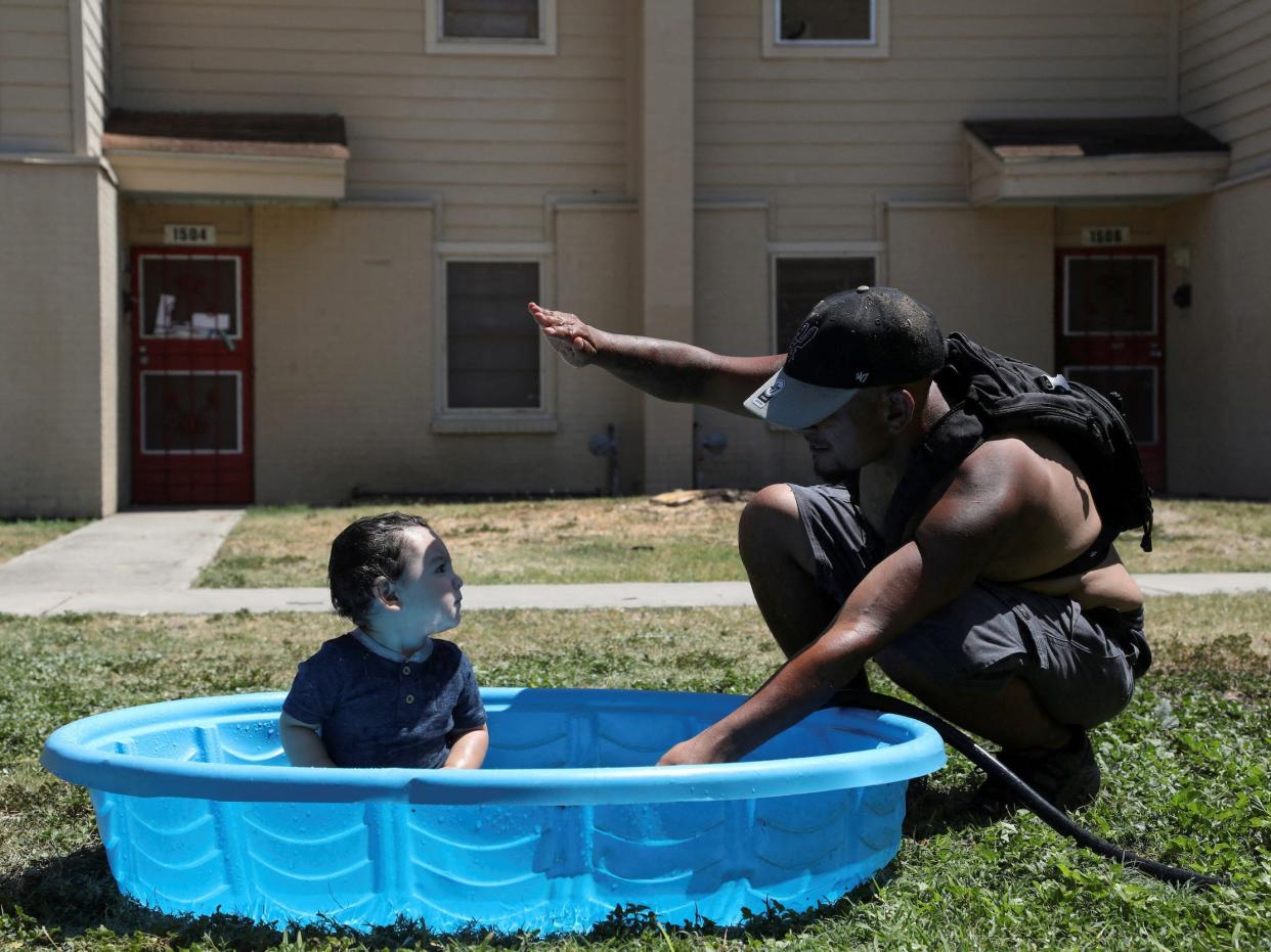 man shields baby's fun from the sun in kiddie pool