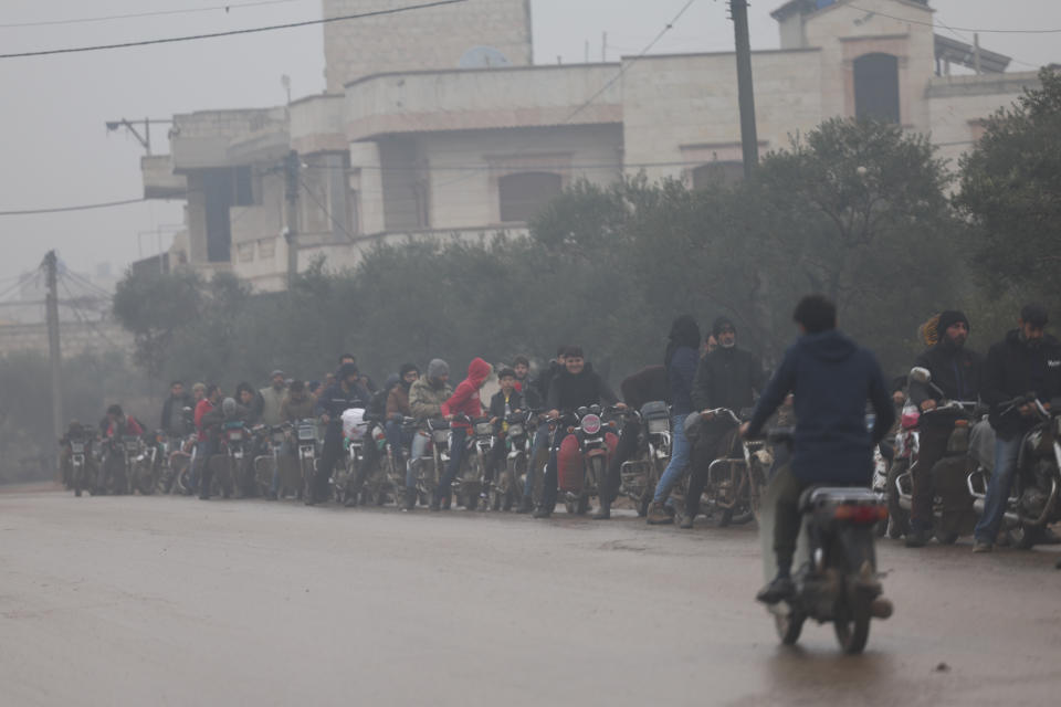 FILE - People queue up for gasoline in Idlib province, Syria, on Dec. 15, 2022. Syria’s president early Wednesday Aug. 16, 2023 doubled public servant and retirees wages and pensions as the war-torn country’s national currency spiraled further downwards, reaching a new low for the year. (AP Photo/Ghaith Alsayed, File)