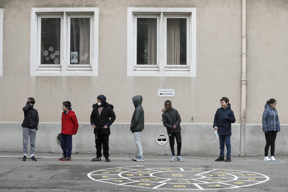 FILE - In this Thursday, May 14, 2020 file photo, schoolchildren wait in line to go back in their classroom at the Sainte Aurelie primary school of Strasbourg, eastern France. France's government is admitting that not all classrooms can safely reopen Tuesday, Sept. 1, 2020 as planned. A persistent rise in virus infections is jeopardizing the government’s push to get France’s 12.9 million schoolchildren back into class. Like many governments, France wants to reopen schools to reduce learning gaps worsened by lockdowns and to get parents back at work and revive the economy. (AP Photo/Jean-Francois Badias, File)