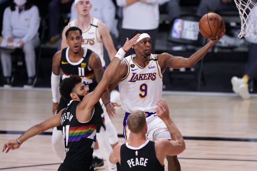 Los Angeles Lakers guard Rajon Rondo (9) takes a shot as Denver Nuggets' Jamal Murray, left, and Mason Plumlee, bottom, defend during the first half of Game 3 of the NBA basketball Western Conference final Tuesday, Sept. 22, 2020, in Lake Buena Vista, Fla. (AP Photo/Mark J. Terrill)