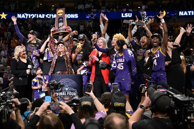 Greg Nelson /Sports Illustrated via Getty LSU head coach Kim Mulkey and her team victorious with trophy after winning national championship game