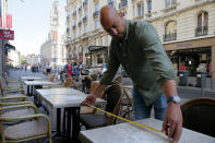 Un hombre mide la distancia entre las meses para respetar las normas de distanciamiento social en un café en Lille, en el norte de Francia, el martes 2 de junio del 2020. (AP Foto/Michel Spingler)