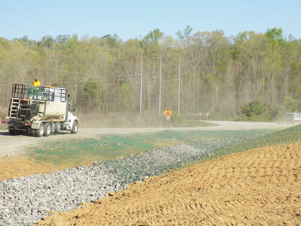 Early site preparation for the Environmental Management Disposal Facility included rerouting portions of Bear Creek Road and the private Haul Road, which is used to ship waste from cleanup sites to the disposal facility. Workers are seen here hydroseeding berms near the facility’s construction area.