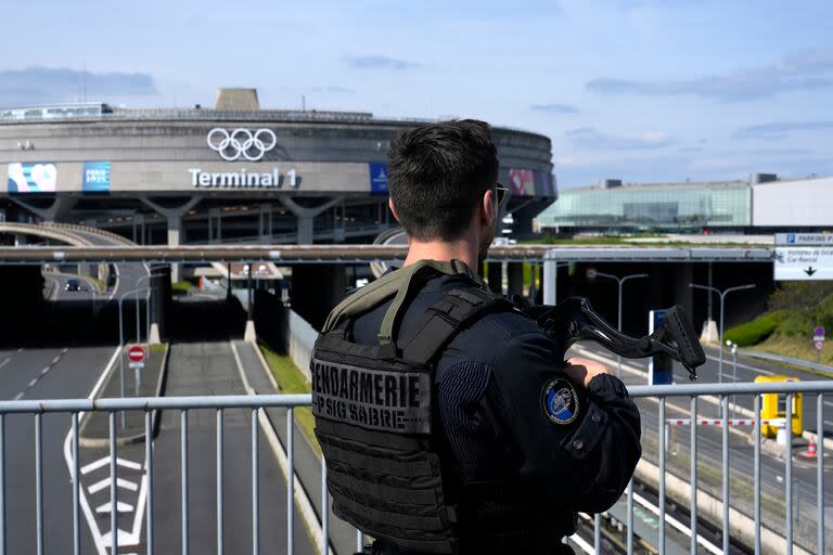 Una patrulla de gendarmes frente a la terminal 1 del aeropuerto Charles de Gaulle, donde se instalaron los anillos olímpicos, en Roissy-en-France, al norte de París, el martes 23 de abril de 2024 en París. (AP Foto/Thibault Camus)