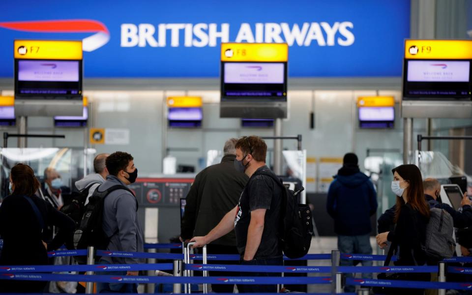 Passengers stand in a queue to the British Airways check-in desks at Heathrow Airport - JOHN SIBLEY/REUTERS